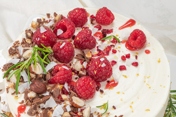 Cheesecake with raspberries, chocolate, hazelnuts and rosemary leaves on kitchen coutertop