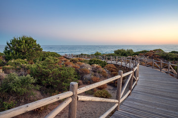 Fototapeta na wymiar Cabopino beach, Marbella, Malaga. Wooden walkway to the beach.