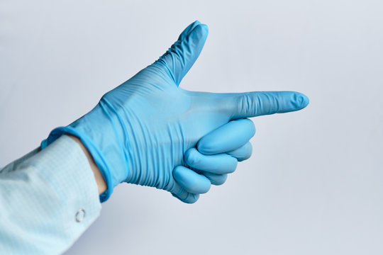 Virus covid-19 and disease control concept - a hand in a medical glove abstractly depicts a gun.