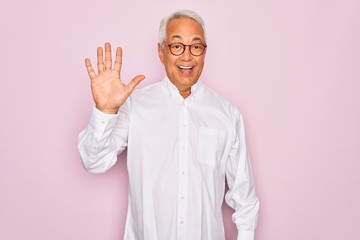 Middle age senior grey-haired man wearing glasses and business shirt over pink background showing and pointing up with fingers number five while smiling confident and happy.