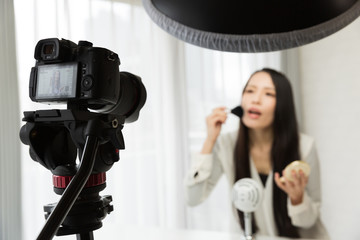 一眼レフカメラで動画を撮影する女性