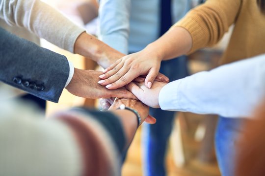 Group of business workers standing with hands together at the office