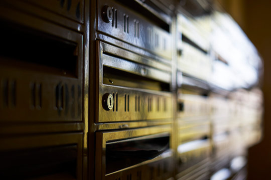 Mailboxes closeup with a locks visible and reflection of outside.