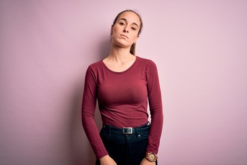 Young beautiful woman wearing casual t-shirt standing over isolated pink background Relaxed with serious expression on face. Simple and natural looking at the camera.