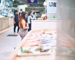 Young beautiful woman smiling happy and confident. Standing with smile on face buying food at supermarket