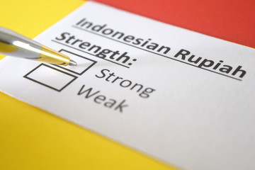 Obraz premium One person is answering question about strength of Indonesian Rupiah.