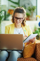 student woman at modern home in sunny day learning online