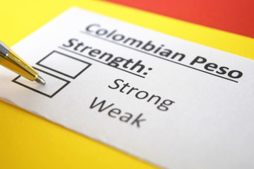 Fototapeta premium One person is answering question about strength of Colombian Peso.