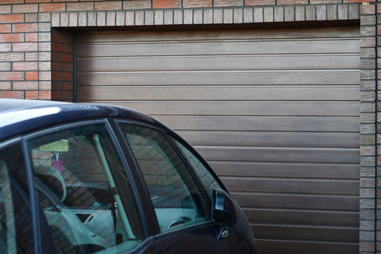 Front Part Of The Car Parked At The Garage Door At Home