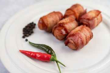 Sausage wrapped pork belly on a white plate.
