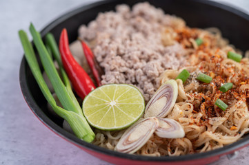 Mama with minced pork in a frying pan.