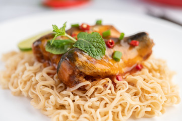 Mama and canned fish in a white dish.