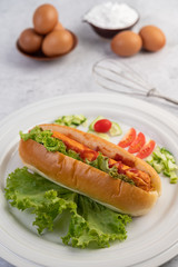 Sausage wrapped in bread and lettuce topped with sauce.