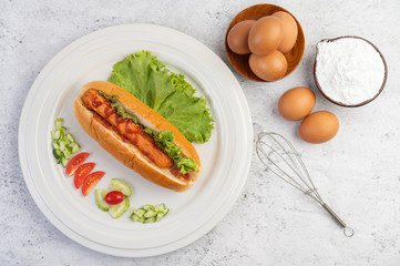 Sausage wrapped in bread and lettuce topped with sauce.