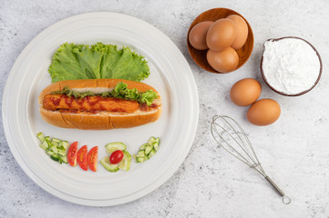 Sausage wrapped in bread and lettuce topped with sauce.