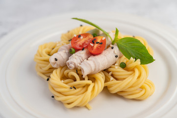 Stir-fried spaghetti and pork, beautifully arranged in a white plate.
