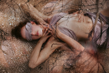 beautiful young woman covered with fabric and blindfolded. double exposure concept