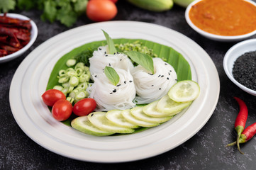 ืRice noodles in a banana leaf with beautifully laid vegetables and side dishes. Thai food.