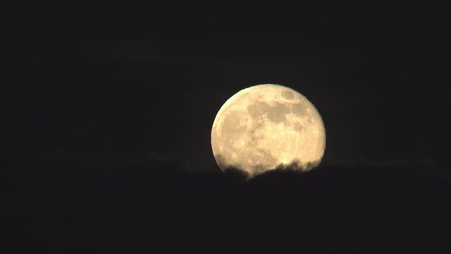 Detailed full moon rising above clouds close up.mov