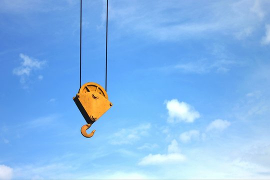 Low Angle View Of Crane Hook Against Blue Sky