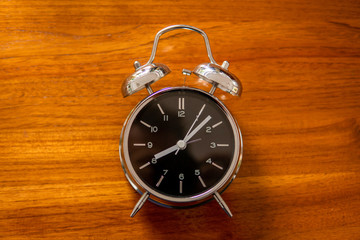 Alarm clock on wood table. Start work concept.