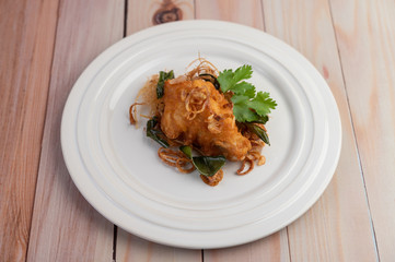 Herb fried chicken on a white plate on a wooden floor