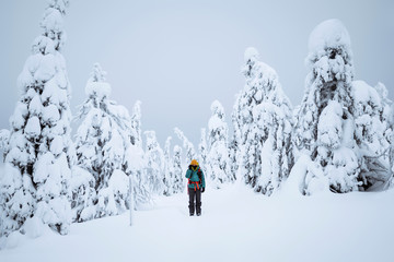 Landscape photographer trekking in a snowy Lapland, Finland
