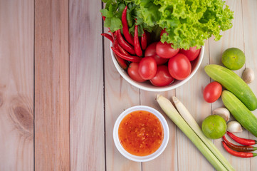 Cucumber, lemon, tomato, garlic, chili with sauce on the wood floor.
