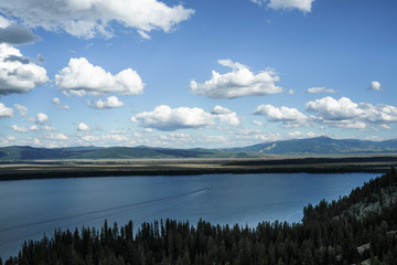 Mountain lake with blue waters, blue sky and deep forrest. Spring waters from mountains. 