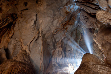 Sunlight shines  in the mouth of big stone cave
