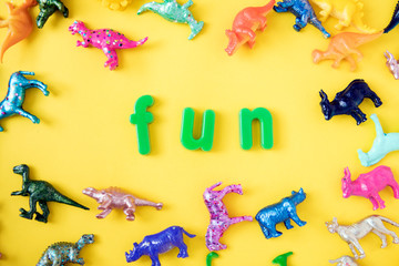 Fototapeta na wymiar Various animal toy figures background with the word fun