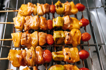 BBQ grill with a variety of meats, complete with tomatoes and bell peppers.
