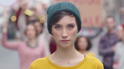 Portrait of confident woman in march fighting for freedom. Young latin woman empowerment strike on street. Casual girl in march to protest on equality rights. Happy smiling woman looking at camera.