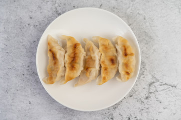 Gyoza in a white dish.