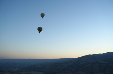 Panoramic view of mountain landscape with hot air balloon floating in the sky