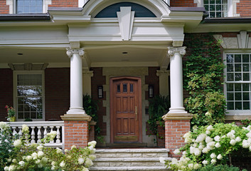 Large old fashioned porch surrounded by hydrangea bushes