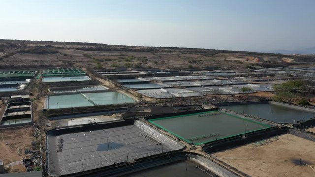 shrimp farm, prawn farming with with aerator pump oxygenation water near ocean. aerial view fish farm with ponds growing fish and shrimp and other seafood, Minh Dinh, Ninh Thuan, Vietnam