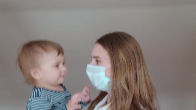 The mother talks to the child through a medical mask. Demonstration of medical equipment. The concept of quarantine, self-isolation, protection from coronavirus, virus, fear of disease, treatment, med