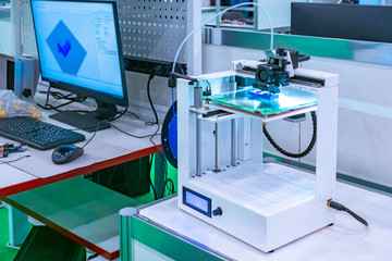 The 3d printer is next to the computer. 3d printer in the lab. Modern printing technologies. Creating three-dimensional images. Layer-by-layer printing of objects.