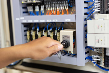 Technician setting  electric control box of machine in factory 
