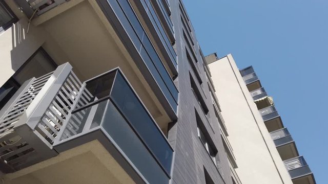 moving below modern residential building with dark gray fasade