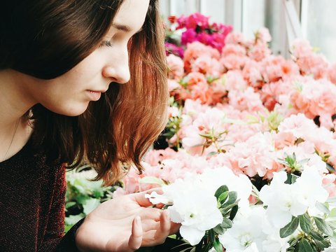 Young Woman Examining Flowers At Shop