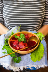 Red borsch - homemade Russian traditional vegetables soup with cabbage, sauerkraut, beetroot and parsley. Vegan healthy food. Ingredients. Woman hands