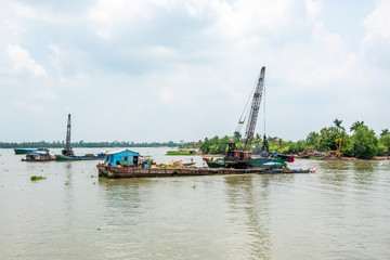 Exploiting sands on the Mekong River. Boats carrying sand on the river in Vinh Long, Vietnam.