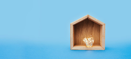 Banner a small wooden empty house with rolled up garlands inside on a blue background.