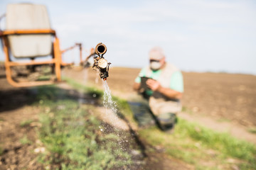 farmer controls the operation of the sprayer. agronomist uses modern technology in his fields. the farmer uses the tablet during field work