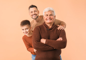 Man with his father and son on color background - obrazy, fototapety, plakaty