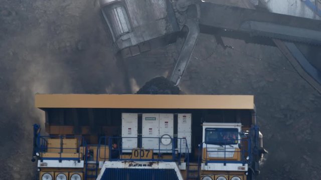 mining truck is loaded in the career in slow motion