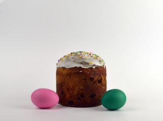 
two fresh painted eggs and Easter cake lie on a white paper background