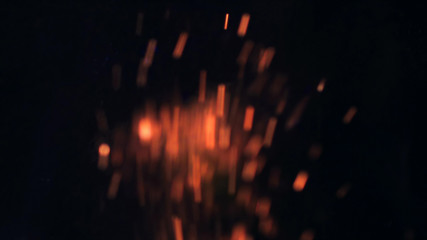 Macro footage of Bonfire sparks. Fire Flames bursts, fire blasts. Explosion micro sparkles. Mini Fireworks. Shooting on Red camera, slow motion on black background. Beautiful leaks overlay spark.
